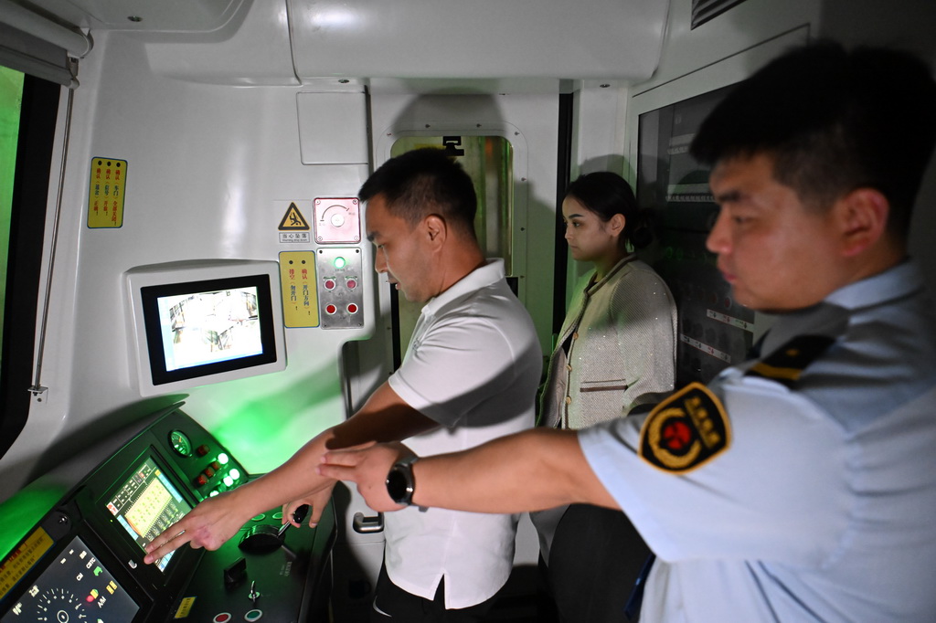 在天津地铁10号线梨园头车辆段，来自哈萨克斯坦的学员达尔罕（左）在中方教师张垚（右）的指导下夜间在天津地铁10号线上考试（9月5日摄）。