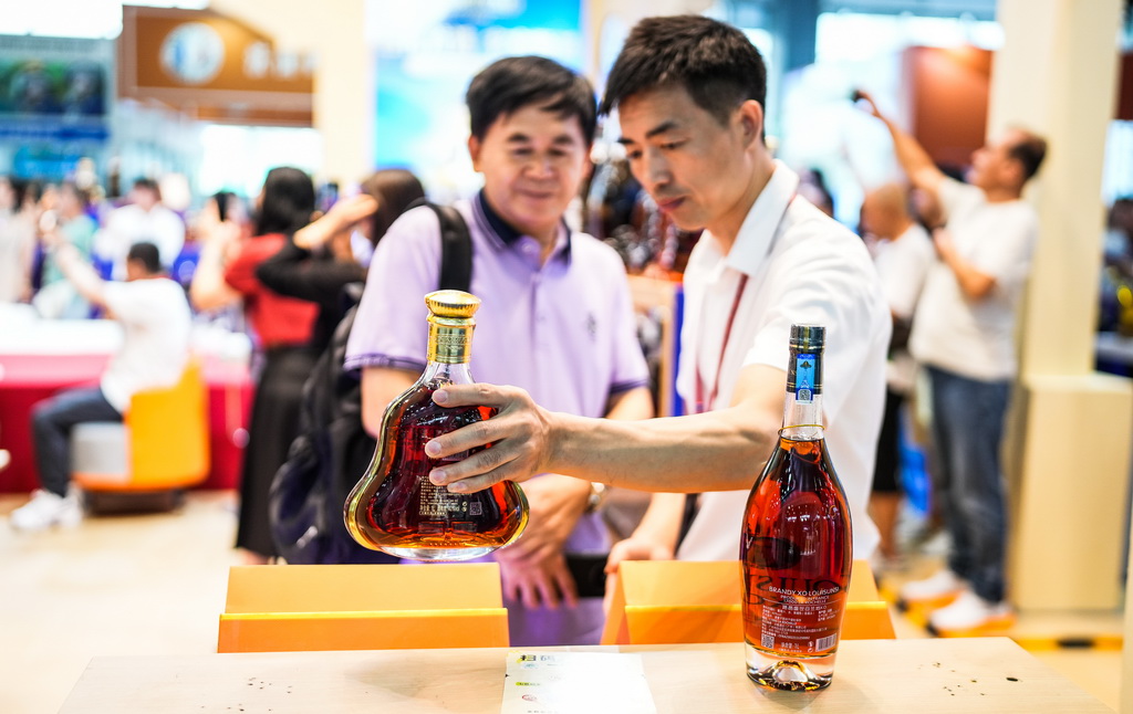 9月9日，参展商在酒博会现场向消费者推介酒类商品。