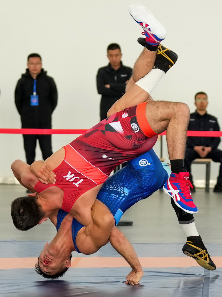 9月9日,塔吉克斯坦(红)与哈萨克斯坦的参赛队员在勇士摔跤比赛中。