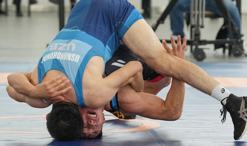 9月9日，哈萨克斯坦（红）与乌兹别克斯坦的参赛队员在勇士摔跤比赛中。