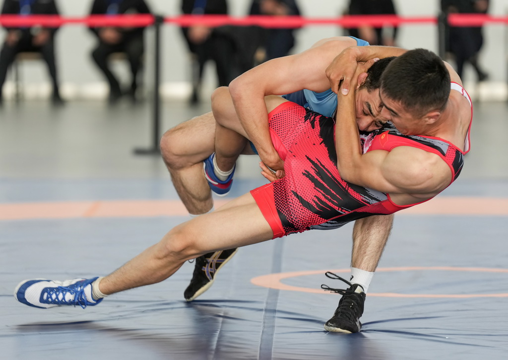 9月9日,吉尔吉斯斯坦(红)与乌兹别克斯坦的参赛队员在勇士摔跤比赛中。