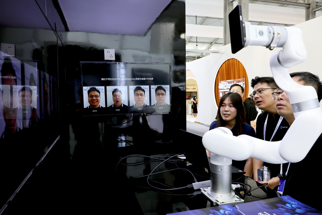 9月10日,參觀者在一個甄別AI換臉技術的演示設備前駐足觀看。