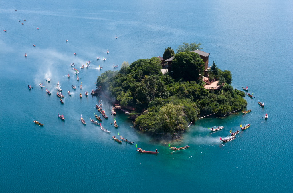 9月16日，当地群众驾着猪槽船在泸沽湖的王妃岛转海（无人机照片）。