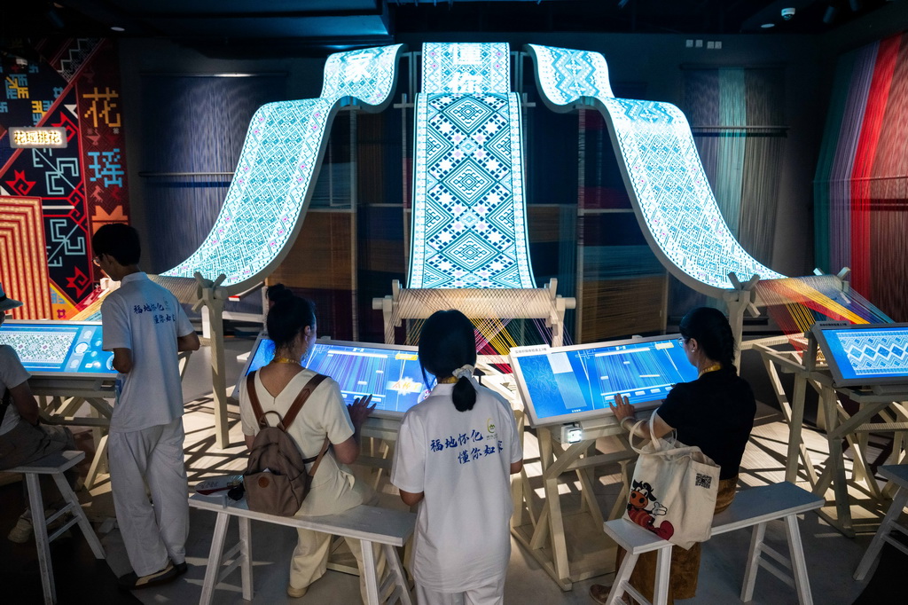 9月16日，在湖南省懷化市五溪非遺園，游客在體驗數字化織錦。