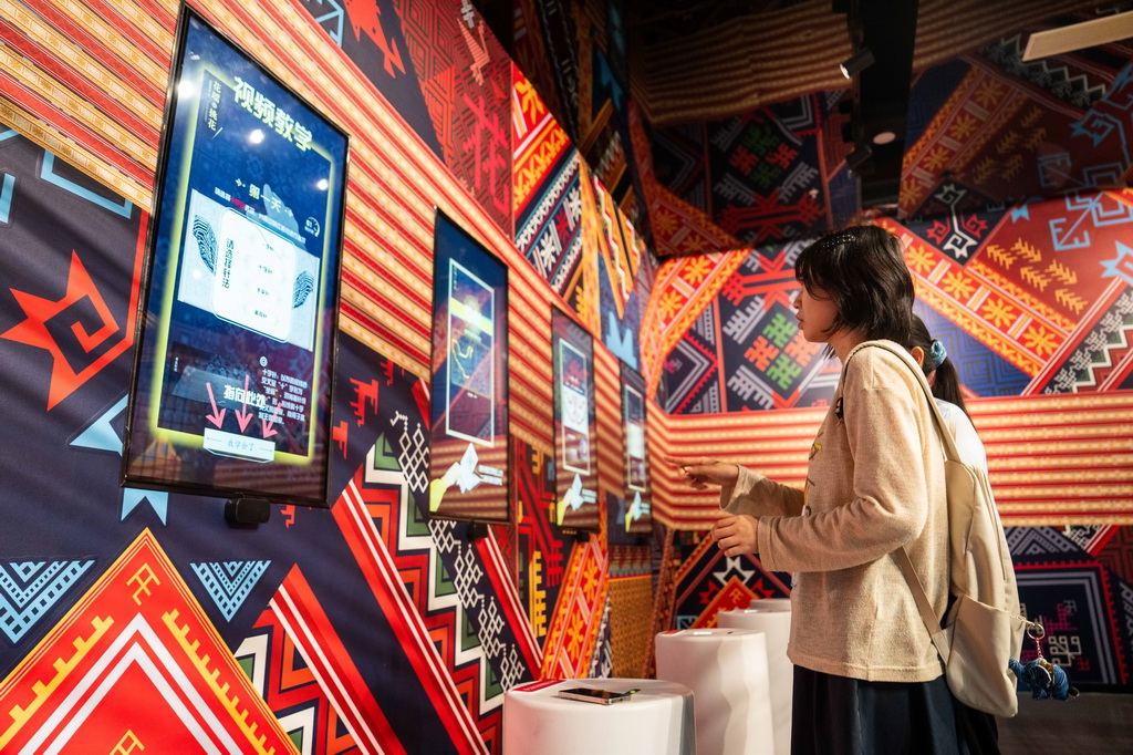 9月16日，在湖南省懷化市五溪非遺園，游客在體驗數字化花瑤挑花。