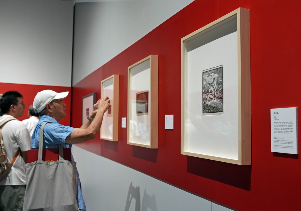 9月18日,观众在展览上欣赏版画作品。