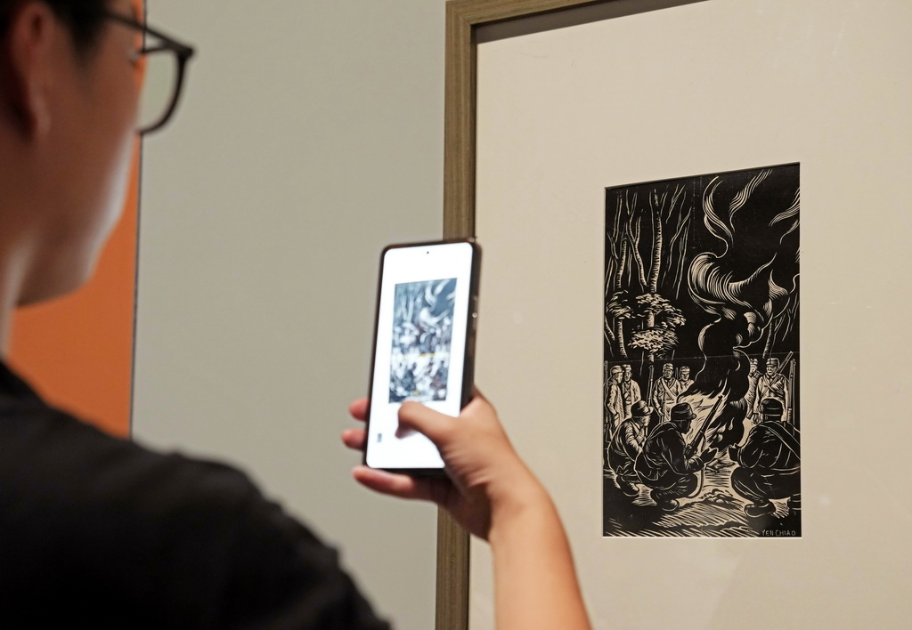 9月18日,观众在欣赏版画家陈烟桥的作品《营火》。