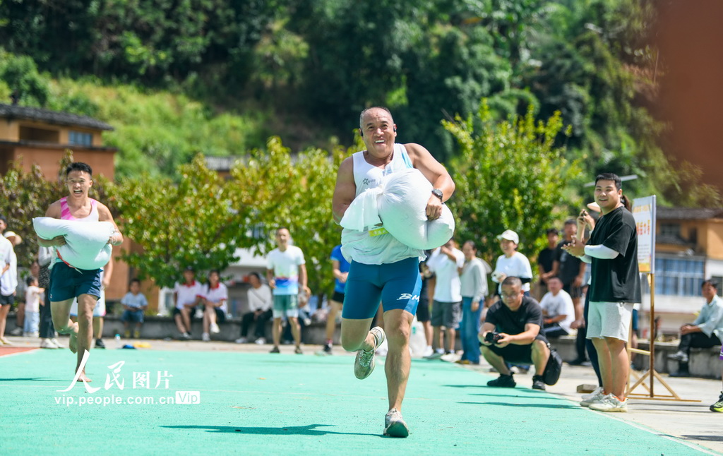 9月20日，贵州省黔西南布依族苗族自治州册亨县者楼街道高峰村，当地群众在参加运粮接力比赛。