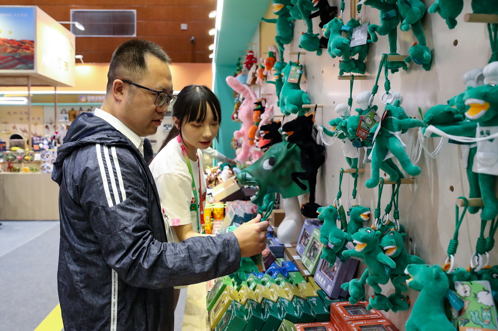 9月21日，與會嘉賓在第八屆絲綢之路（敦煌）國際文化博覽會上選購非遺文創產品。