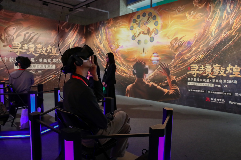 9月21日，在第八屆絲綢之路（敦煌）國際文化博覽會上，與會嘉賓借助VR設備沉浸式游覽莫高窟虛擬場景。