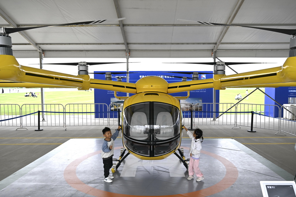 9月21日，小朋友在“全空间无人体系成果展”上参观一款无人驾驶电动垂直起降航空器。