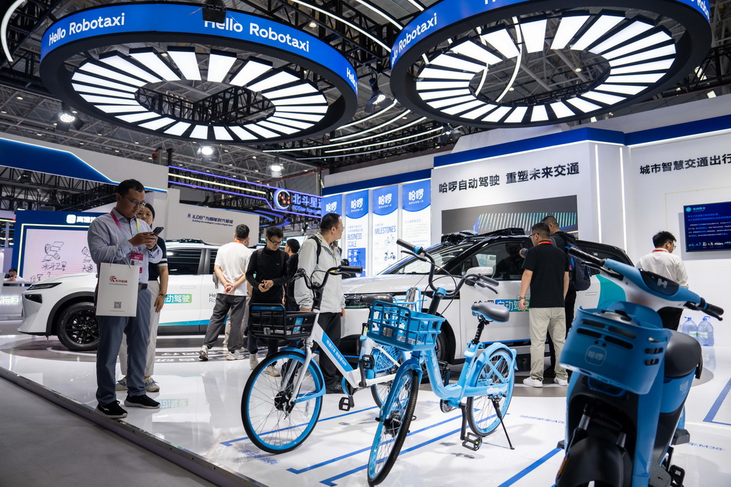 9月24日，在株洲国际会展中心，观众（左一）在拍摄配有北斗技术的共享单车。