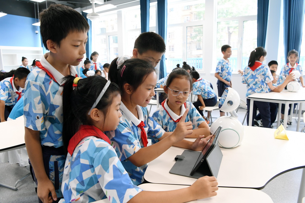 9月24日,北京市第二十中学附属育鹰小学学生在人工智能教育通识课《从国防到生活——AI人脸识别》了解人脸识别技术。