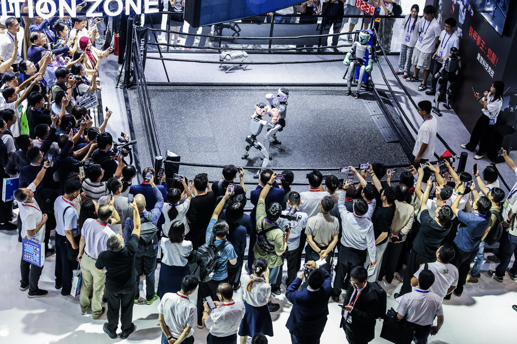 9月25日,在第四届全球数字贸易博览会数智未来主题展区的杭州六小龙专区,观众观看宇树科技的人形机器人进行格斗擂台赛。