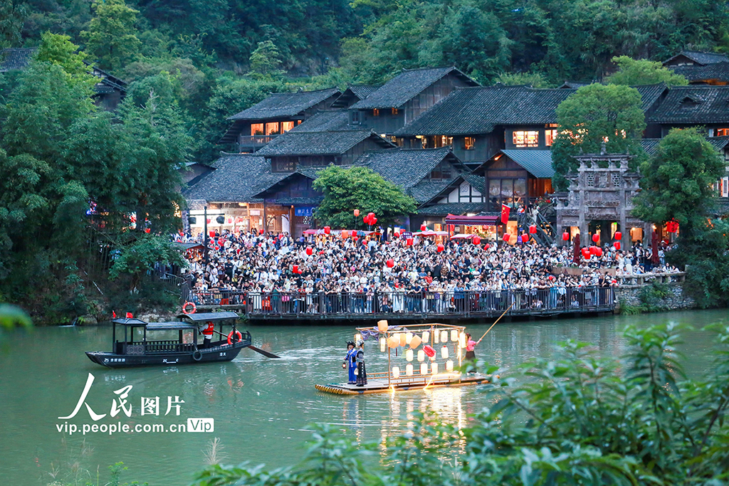 10月1日，游客在贵州省遵义市播州区乌江寨景区观看山歌对唱表演。李仁军摄（人民图片网）