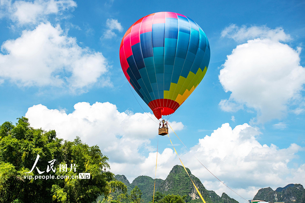 10月2日，游客在广西崇左市大新县堪圩乡明仕村乘坐热气球游览田园风光。赵京武摄（人民图片网）