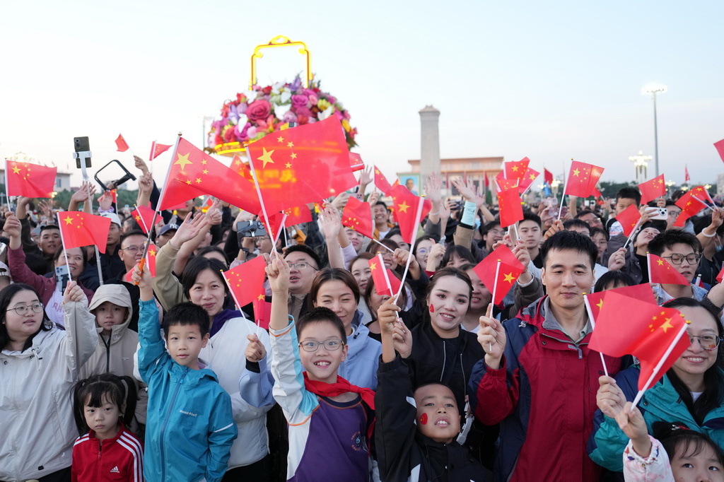 10月1日清晨，隆重的升国旗仪式在北京天安门广场举行，庆祝中华人民共和国成立76周年。这是观众在升旗仪式后欢呼。 新华社记者 鞠焕宗 摄