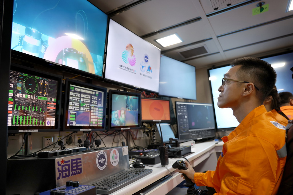 在科考船上的“海马”号深海遥控潜水器控制室里，工作人员遥控采火装置在海底进行作业（9月18日摄）。