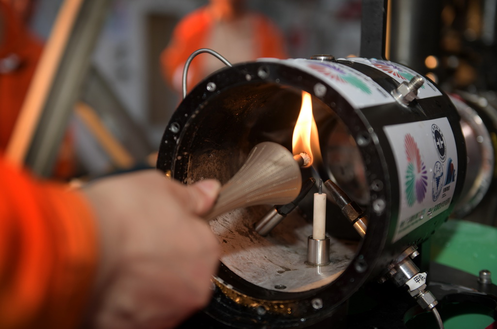 在科考船甲板面，工作人员从搭载在“海马”号深海遥控潜水器上的采火装置里取火（9月18日摄）。
