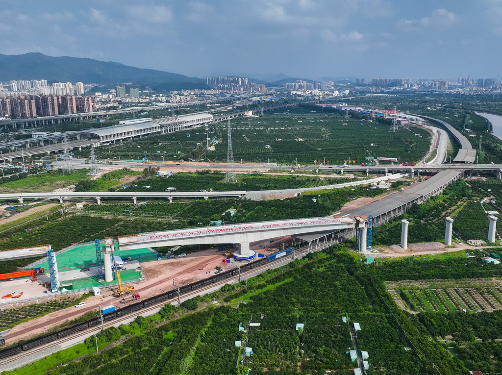 10月10日，一列货运列车从转体成功后的深江铁路广中江特大桥跨广珠货运铁路转体桥下驶过（无人机照片）。