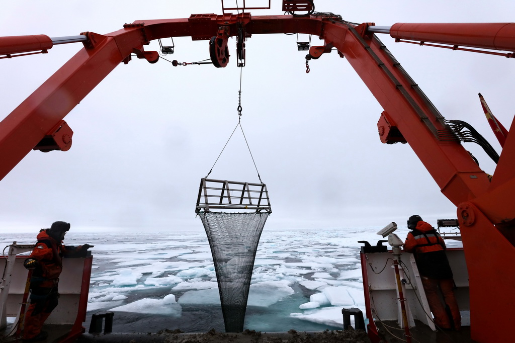 图为科考队员正在回收底拖网。新华社记者 刘诗平 摄