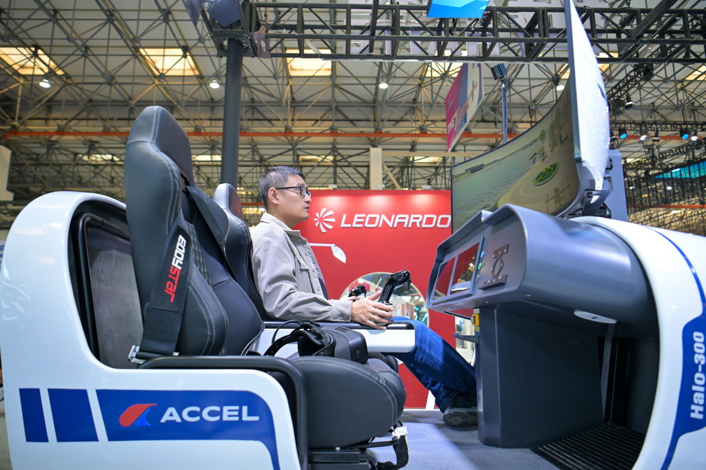 10月14日,工作人员在天津直博会直升机馆内调试模拟飞行体验设备。新华社记者 孙凡越 摄