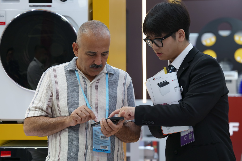  10月15日，客商在广交会上洽谈。