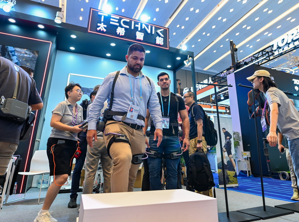 10月15日，境外采购商在第138届广交会服务机器人专区太希智能展台体验登山助行外骨骼穿戴设备。新华社记者 肖恩楠 摄