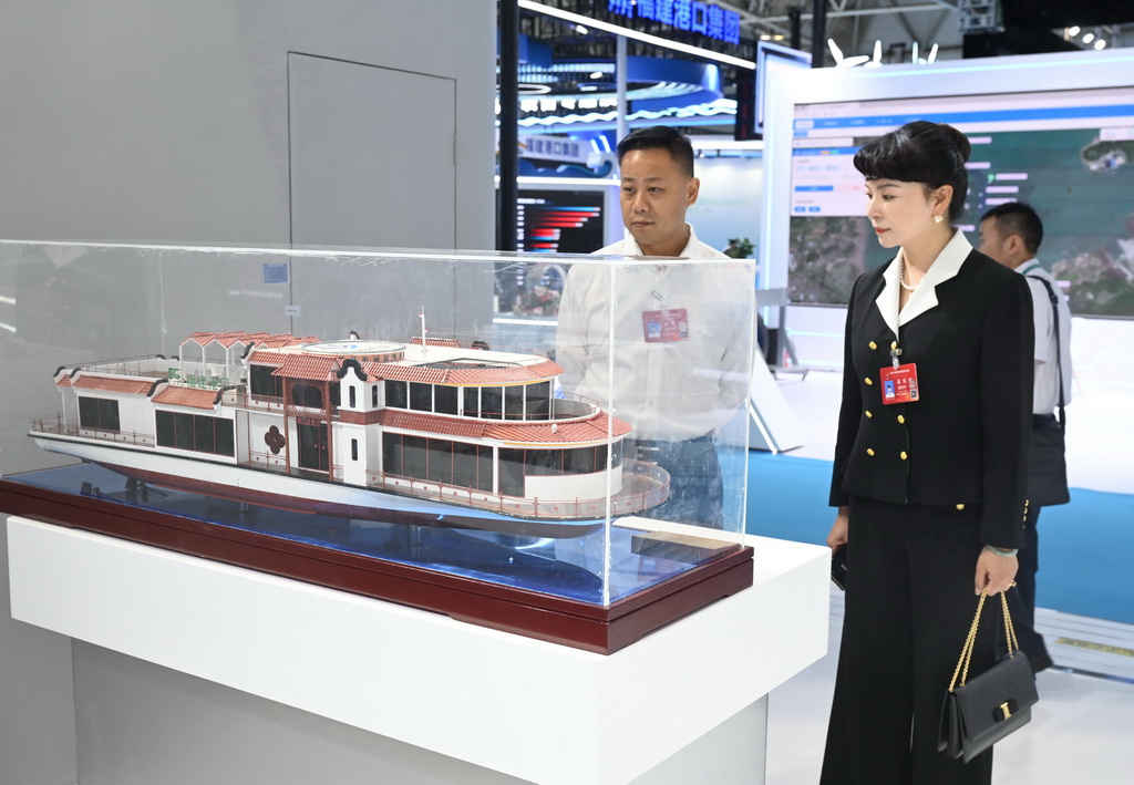 10月16日,与会人员在宁德时代展区观看“闽江会客厅”电动游船模型。新华社记者 林善传 摄