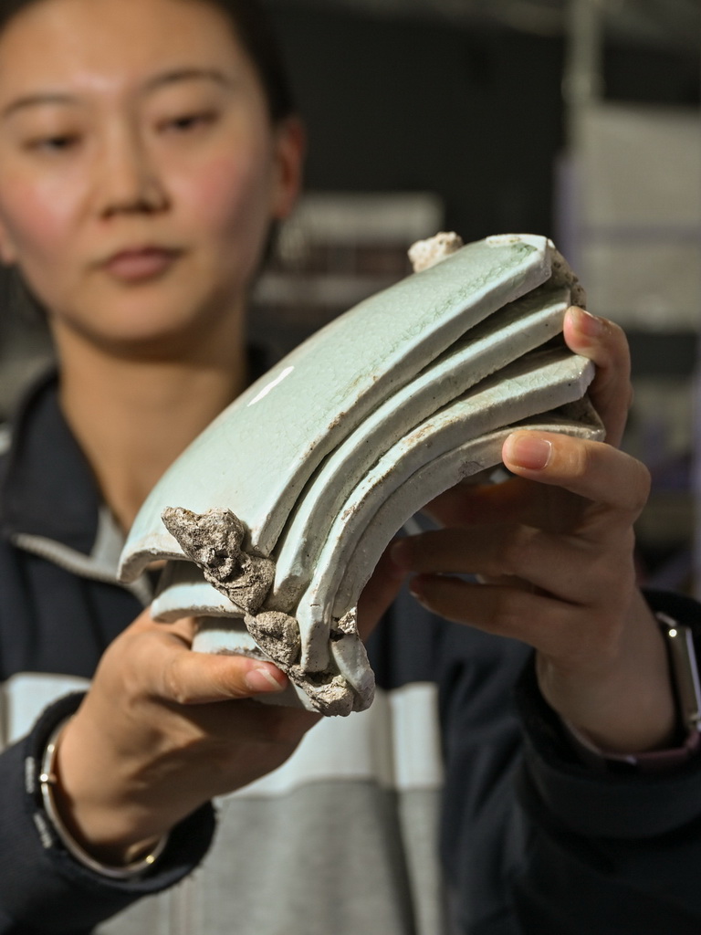 一位工作人員在蘇峪口瓷窯址考古隊文物庫房內展示發掘出土的白瓷板瓦標本（10月13日攝）。新華社記者 李賀 攝