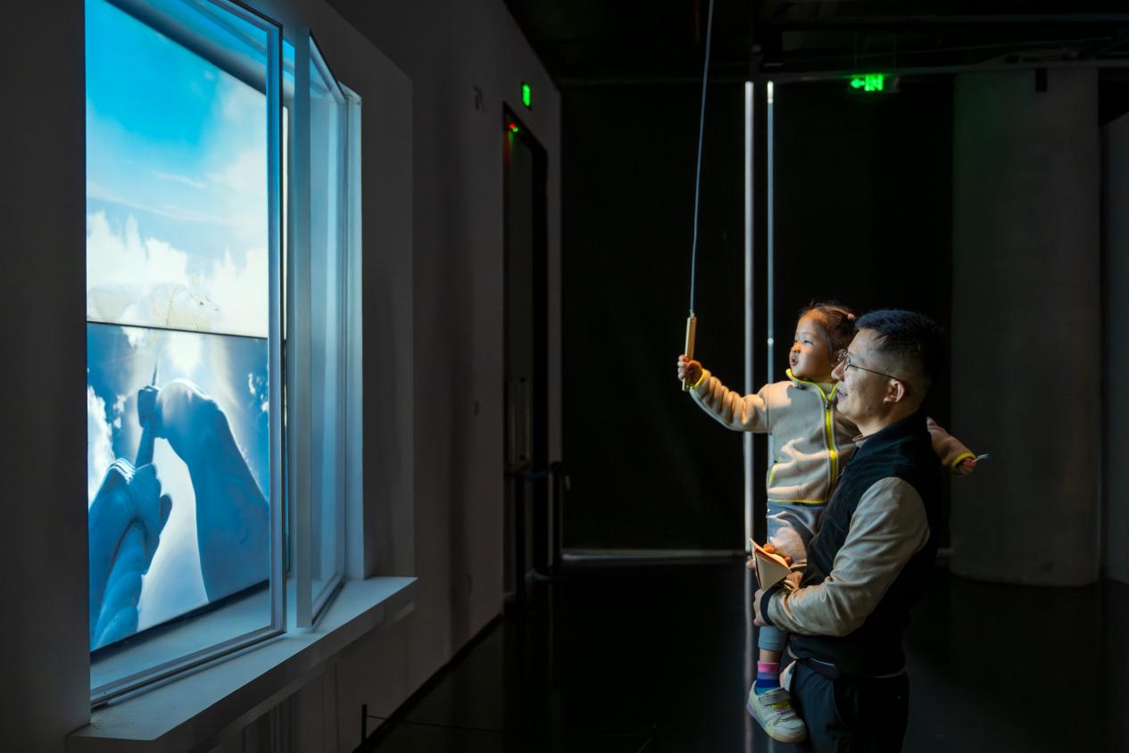 成都市美术馆内,观众在与展厅内的数字屏与光电装置进行互动。嘉楠摄