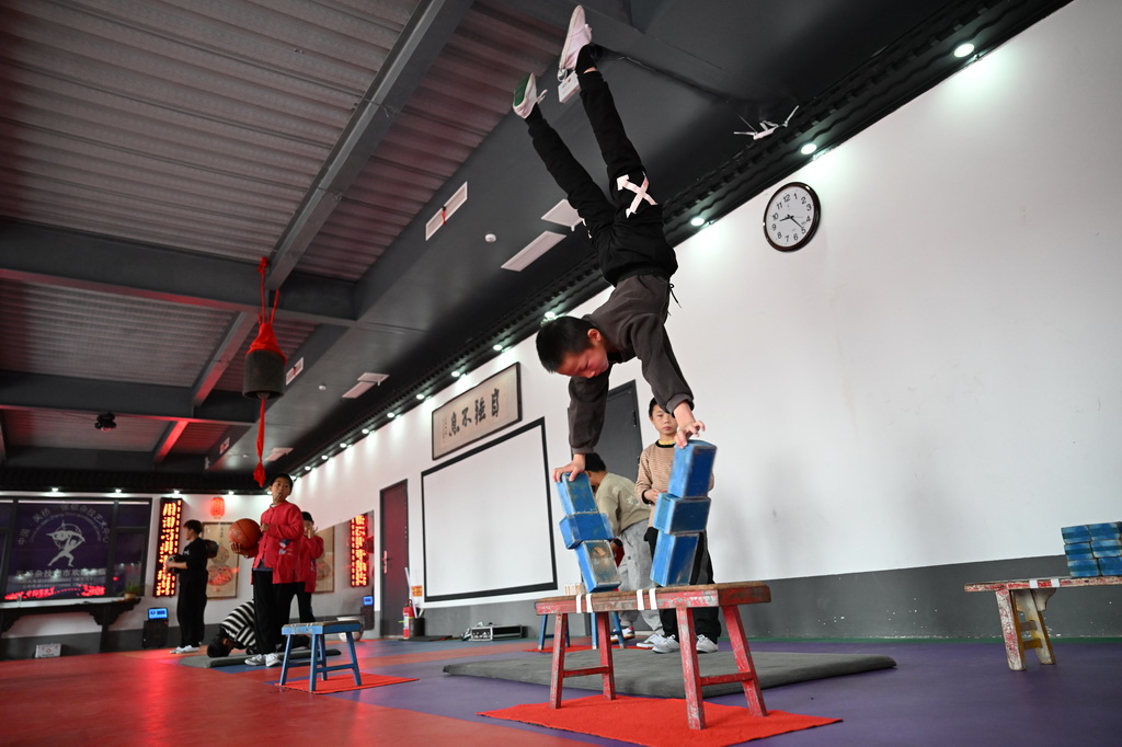 10月28日,河北省沧州市吴桥县大运河堤顶路沿线张硕杂技小院的学员练习杂技。