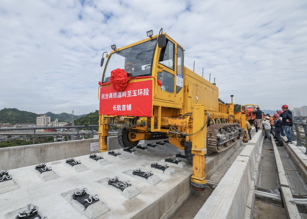11月5日，在浙江省台州市杭台高鐵溫嶺至玉環段施工作業現場，中鐵十四局工作人員操作長軌牽引車將首段500米長鋼軌精准鋪設在無砟道床上。