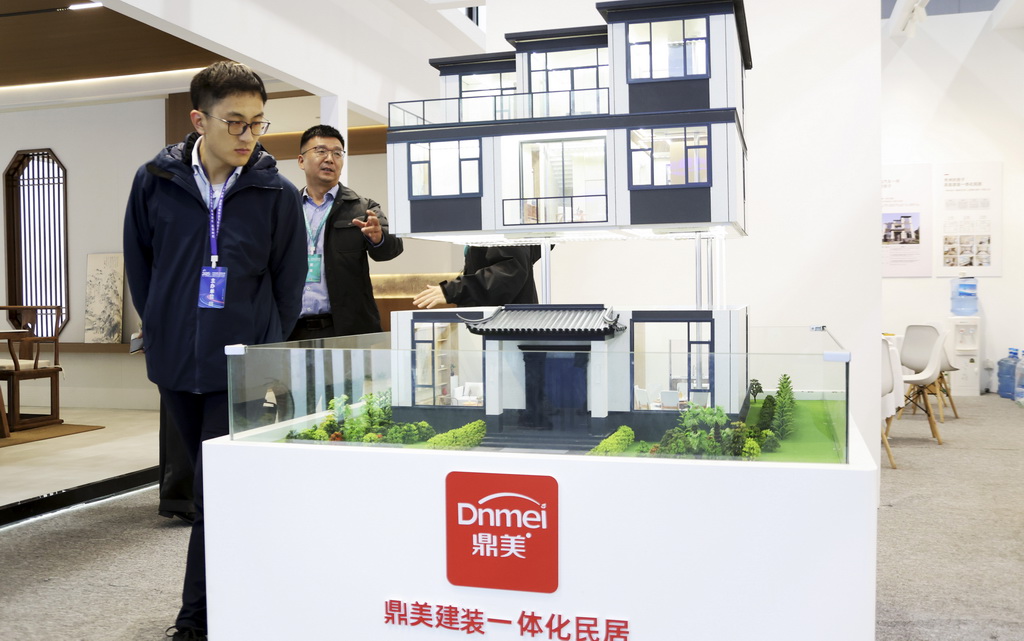 11月6日，參觀者在住博會上觀看展出的一體化民居模型。
