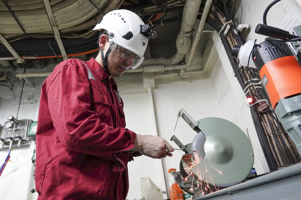 北京时间11月8日,大管轮董恒在机修间制作检修工具。新华社记者 顾天成 摄