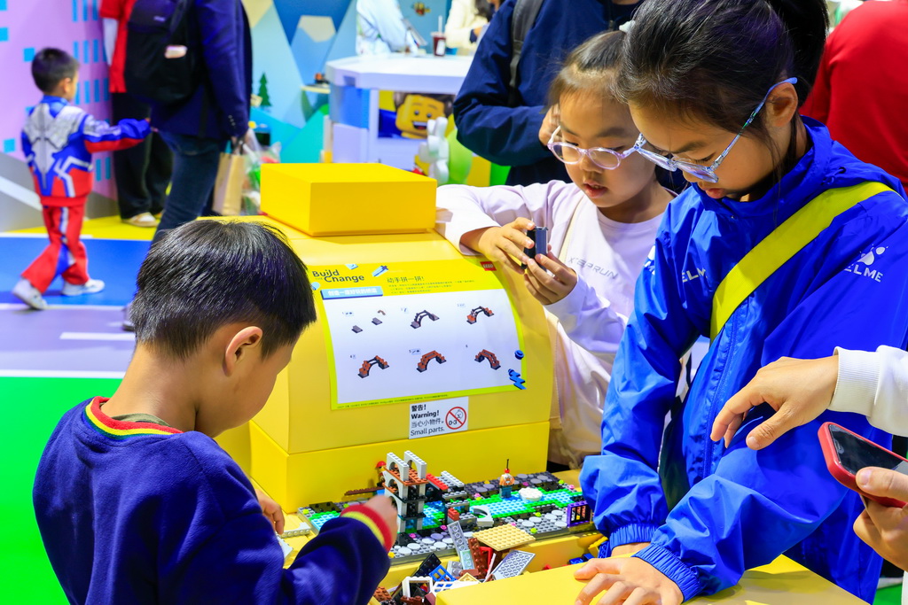 11月8日,在第八届进博会消费品展区,儿童在乐高展台动手体验积木。新华社记者 刘佳琪 摄