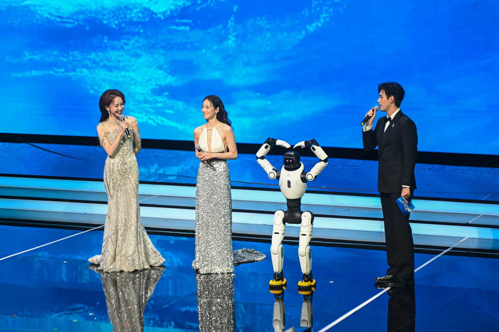 11月11日晚，主持人在2025年中国金鸡百花电影节开幕式现场与机器人互动。