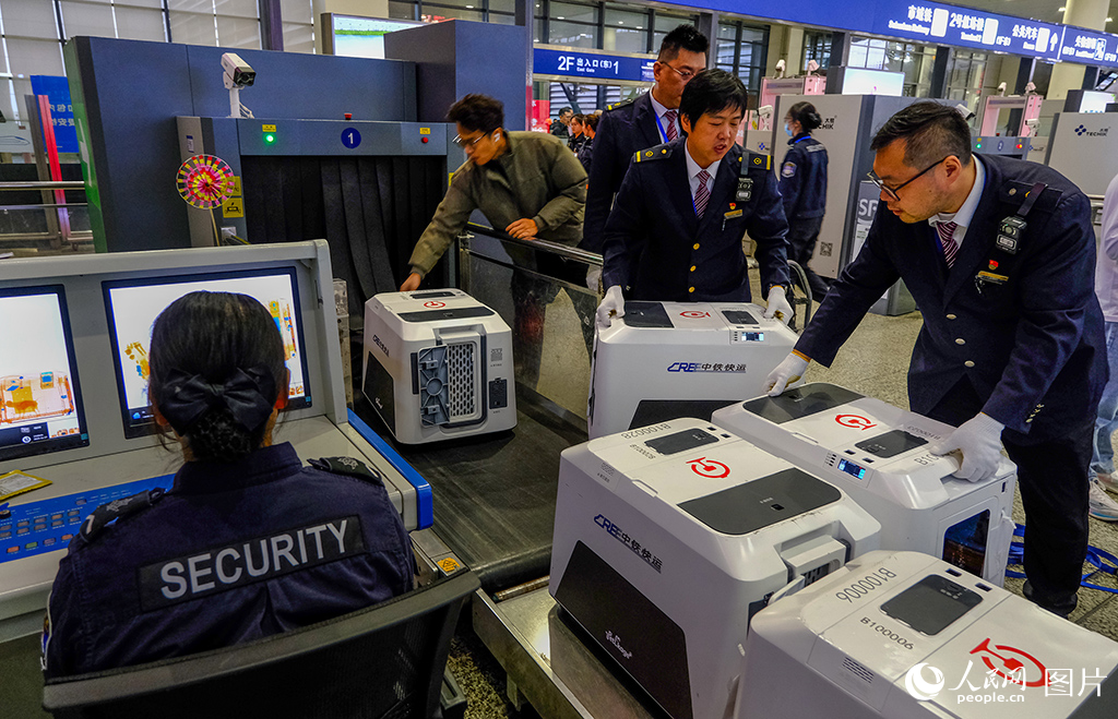 工作人員轉運寵物進站安檢。