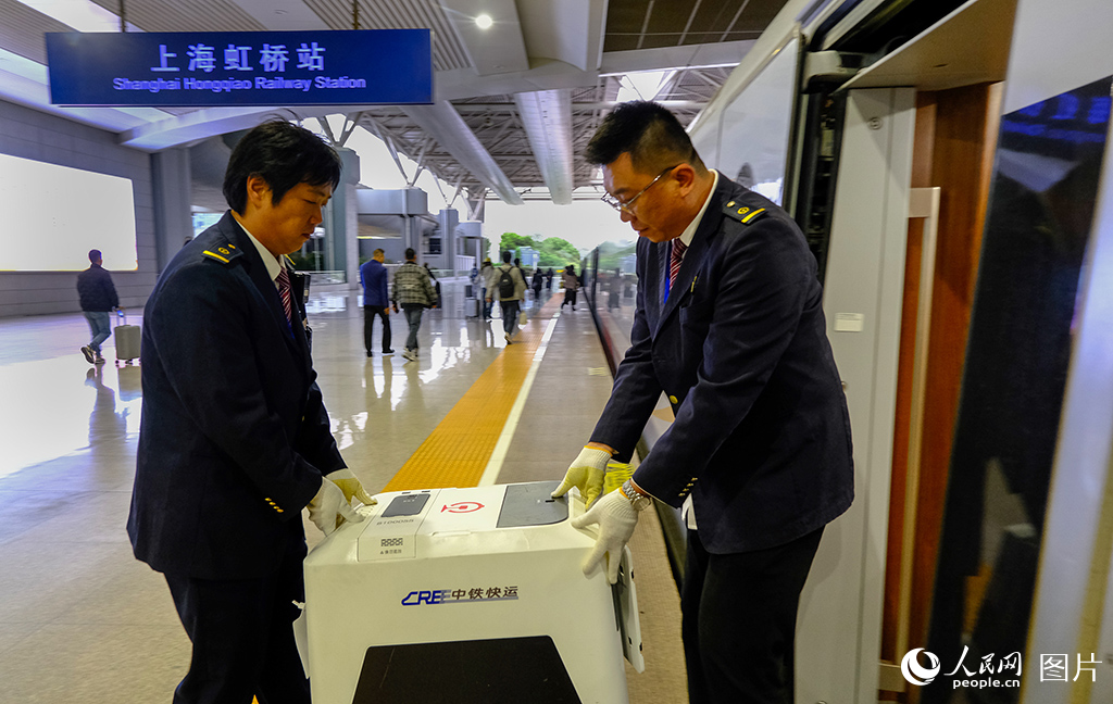 工作人員將寵物托運箱送至高鐵車廂。