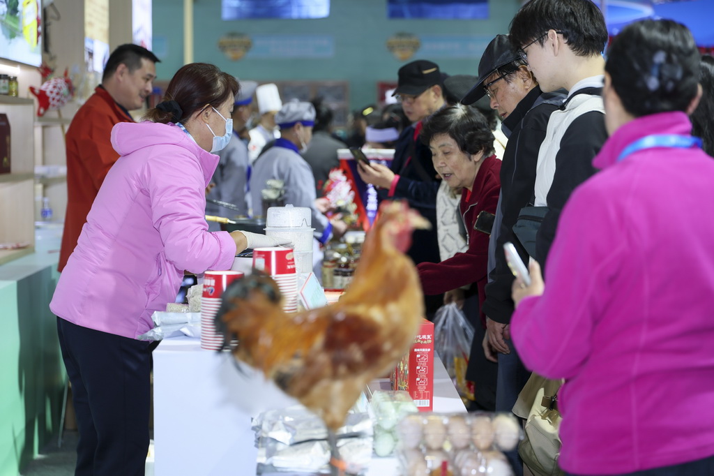 11月20日，觀眾在安徽展區體驗美食。