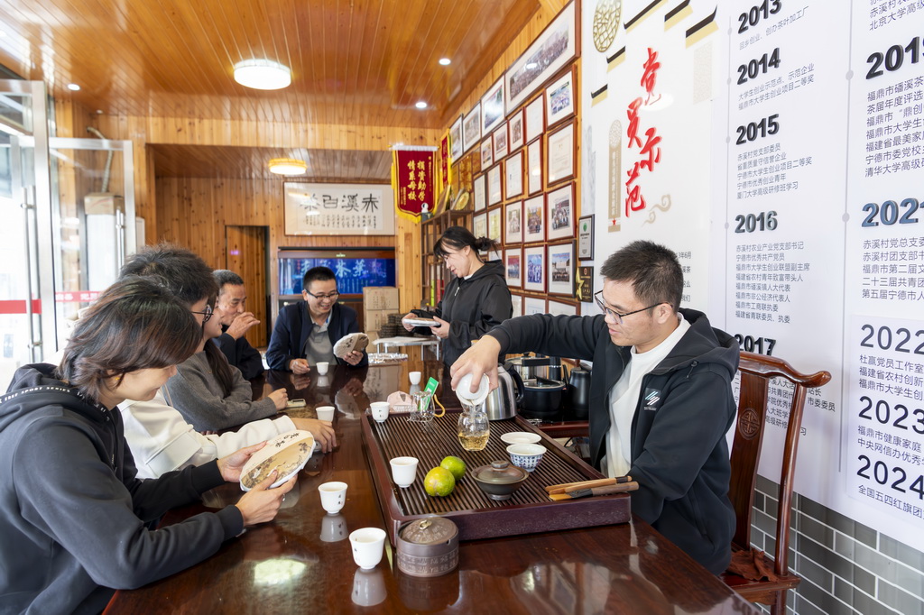 12月2日，返鄉創業大學生杜贏（右一）向村民介紹白茶的加工制作工藝。