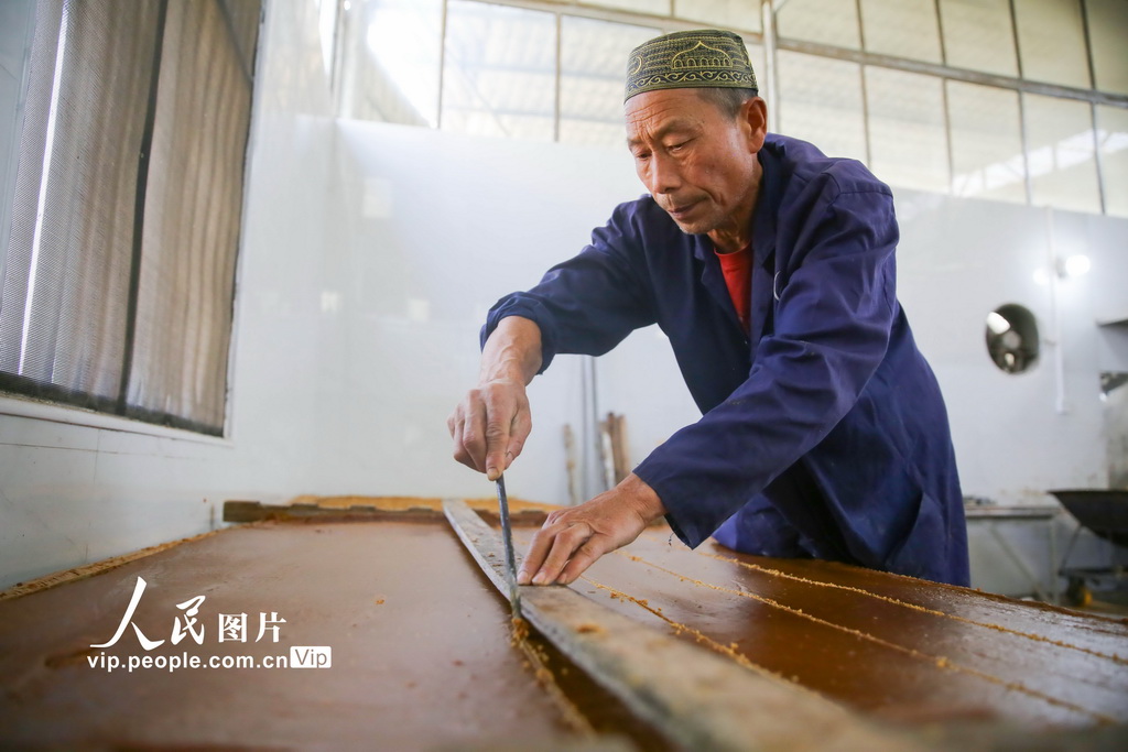 2025年12月6日，湖南省邵阳市隆回县山界回族乡老屋村，工人将冷却的红糖划块。