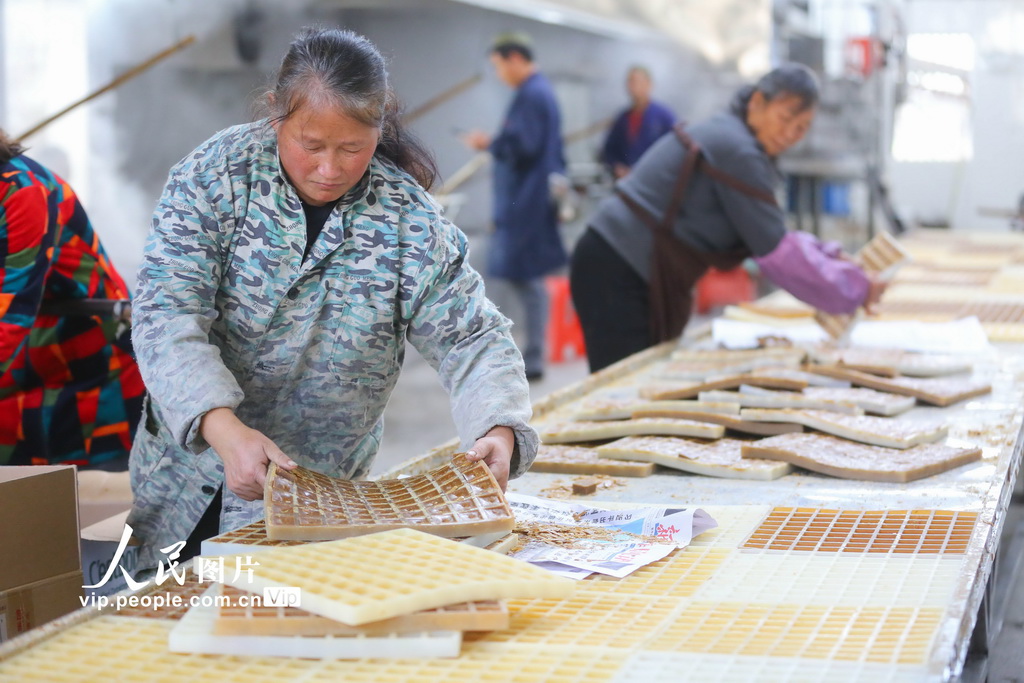 2025年12月6日,湖南省邵阳市隆回县山界回族乡老屋村,工人倒出成型的红糖,准备包装。