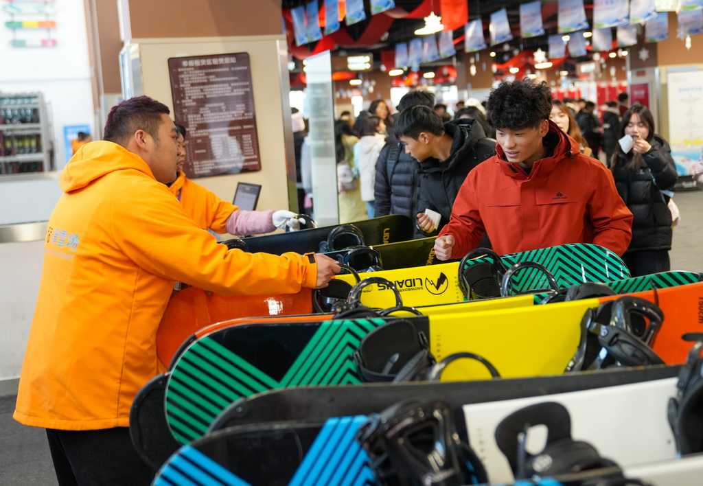 12月8日，在阿坝州汶川县羌人谷滑雪场，游客在装备区取滑雪装备。