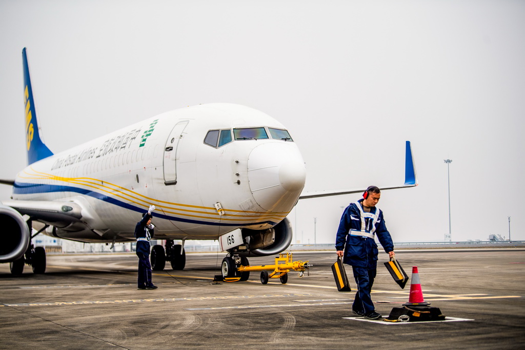 12月9日，工作人员进行中国邮政“重庆至仰光”国际货邮航线首航货机起飞前的准备工作。