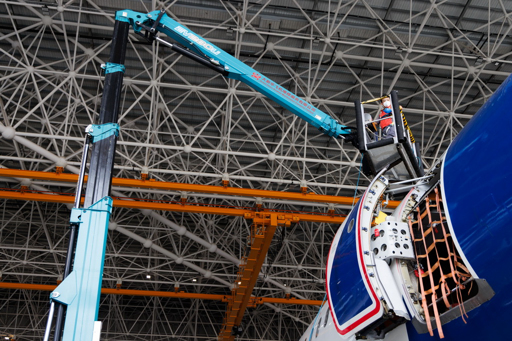 12月9日,工作人员在海南自贸港一站式飞机维修产业基地维修飞机。