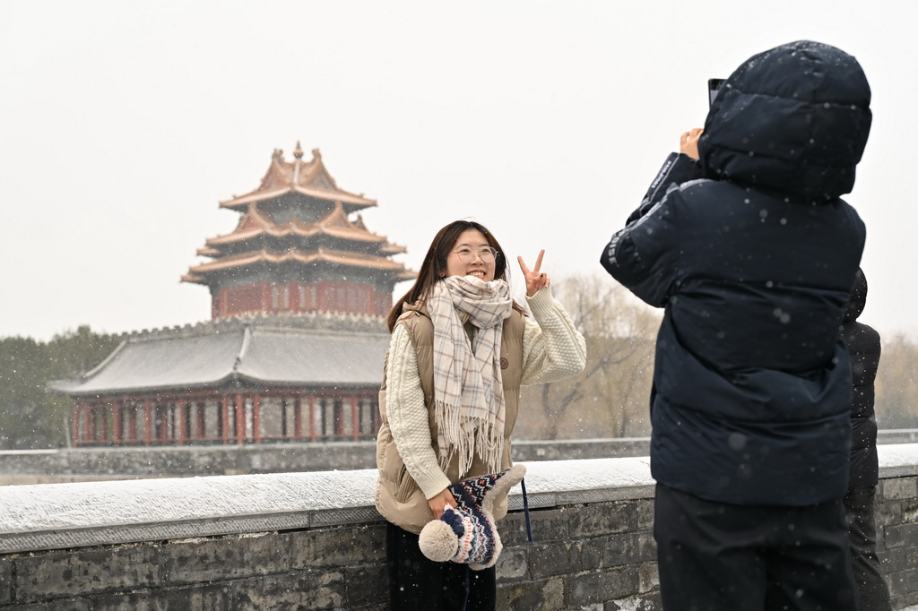 12月12日，游客在北京故宫角楼赏雪拍照。新华社记者 李鑫 摄