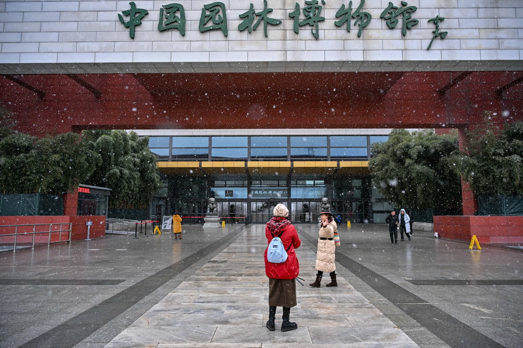 12月12日，游客冒雪在中国园林博物馆参观游览。新华社记者 张铖 摄