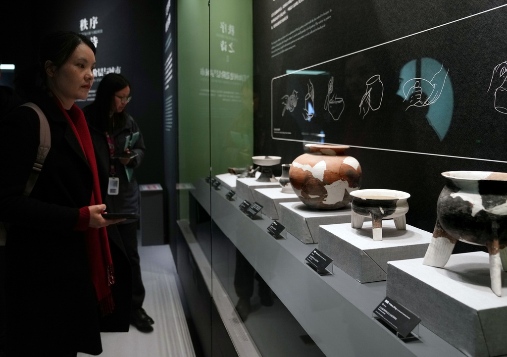 12月12日，参加媒体预览的人员在观看良渚文化陶器。