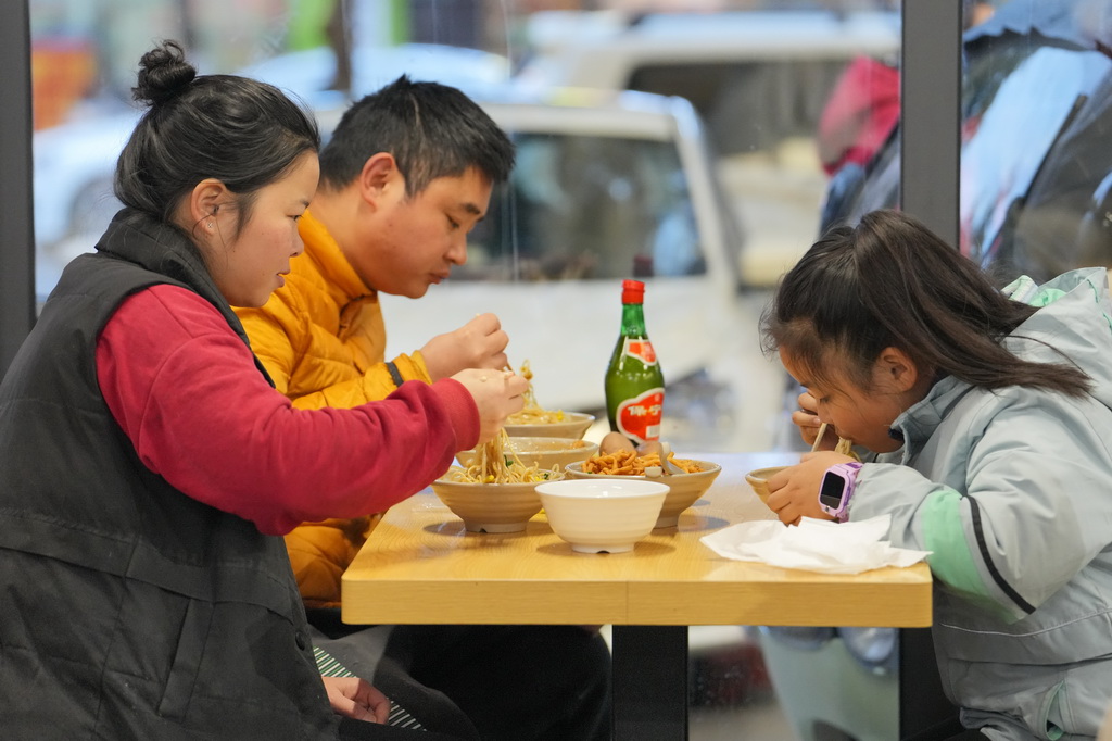 12月12日，在四川省广元市一家凉面馆，一家三口在吃凉面。新华社记者 胥冰洁 摄